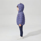 Niño de perfil vistiendo chaqueta acolchada EmpiBy color azul con capucha y orejas de osito, estilo casual infantil.