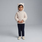 Niña pequeña vistiendo chaqueta acolchada EmpiBy Little Bear color beige con capucha de orejitas de oso