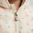 Detalle de cremallera con tirador de conejito en chaqueta acolchada EmpiBy color crema con estampado de conejitos