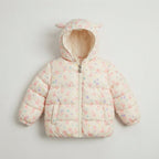 Chaqueta acolchada EmpiBy para niña en color crema con estampado de conejitos y capucha con orejitas decorativas.