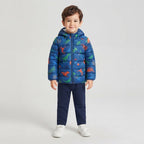 Niño vistiendo chaqueta acolchada azul EmpiBy con estampado de dinosaurios coloridos y capucha sobre fondo claro
