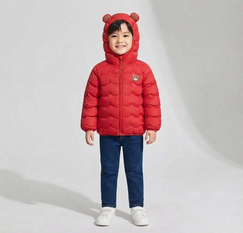 Niño vistiendo chaqueta acolchada impermeable roja de EmpiBy con capucha y orejas de oso, ideal para días de lluvia.