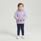 Niña pequeña vistiendo chaqueta acolchada EmpiBy color lila con capucha y orejitas decorativas sobre fondo neutro