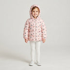 Niña sonriente vistiendo chaqueta acolchada rosa EmpiBy con estampado de pajaritos y capucha