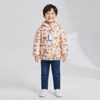 Niño sonriente vistiendo chaqueta acolchada EmpiBy beige claro con estampado de ositos y capucha con orejitas 3D