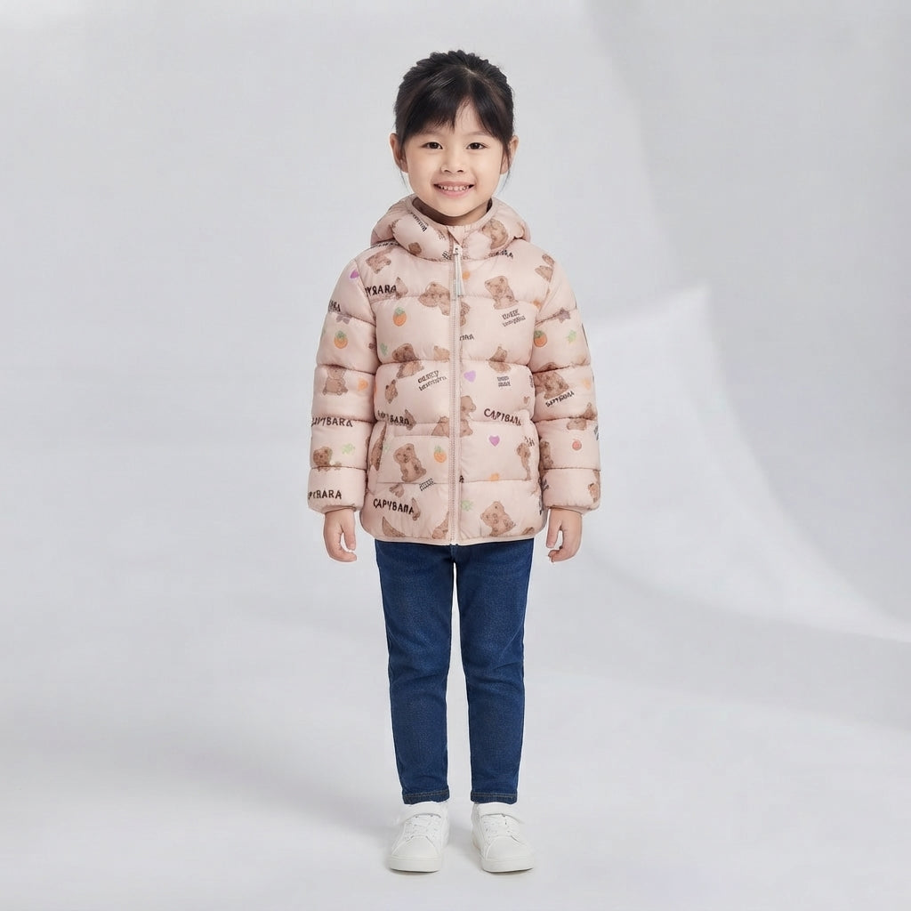 Niña vistiendo chaqueta acolchada EmpiBy beige claro con estampado de ositos y capucha, combinada con jeans azules.