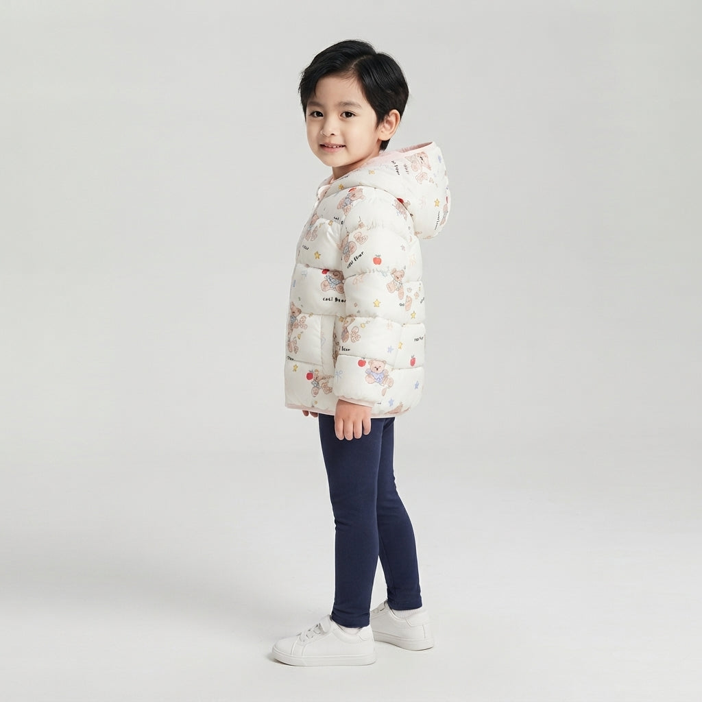 Niña vistiendo chaqueta acolchada EmpiBy con estampado de ositos y manzanas sobre fondo blanco