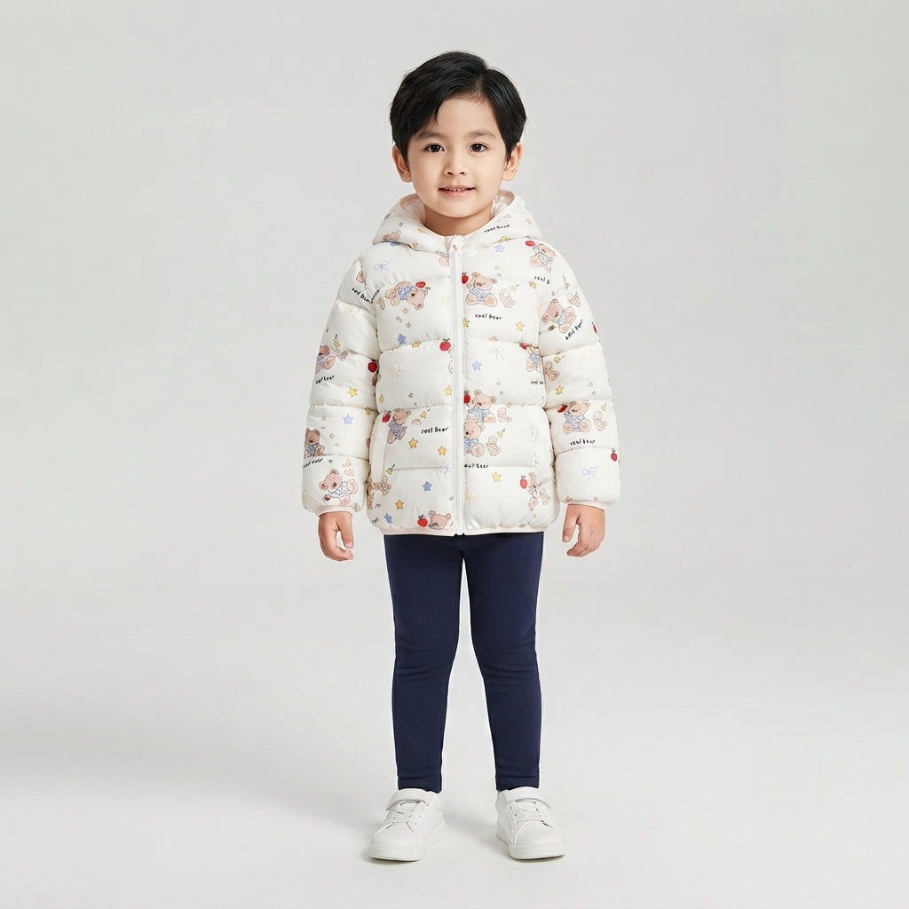 Niña vistiendo chaqueta acolchada EmpiBy blanca con estampado de ositos y manzanas, con capucha y cierre frontal.