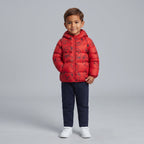Niño vistiendo chaqueta acolchada roja EmpiBy con estampado de caras de oso y capucha, ideal para invierno.