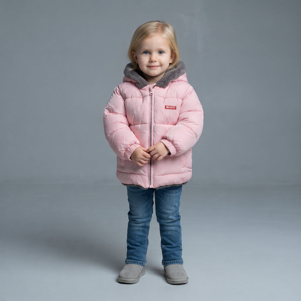 Niña pequeña vistiendo chaqueta acolchada rosa EmpiBy con capucha de forro polar gris y cremallera frontal