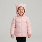 Niña sonriente vistiendo chaqueta acolchada rosa EmpiBy con capucha y orejitas decorativas para bebé