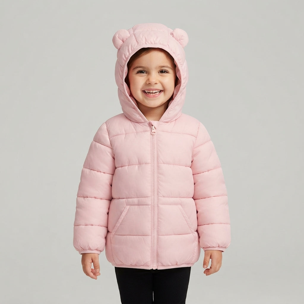 Niña sonriente vistiendo chaqueta acolchada rosa EmpiBy con capucha y orejitas decorativas para bebé