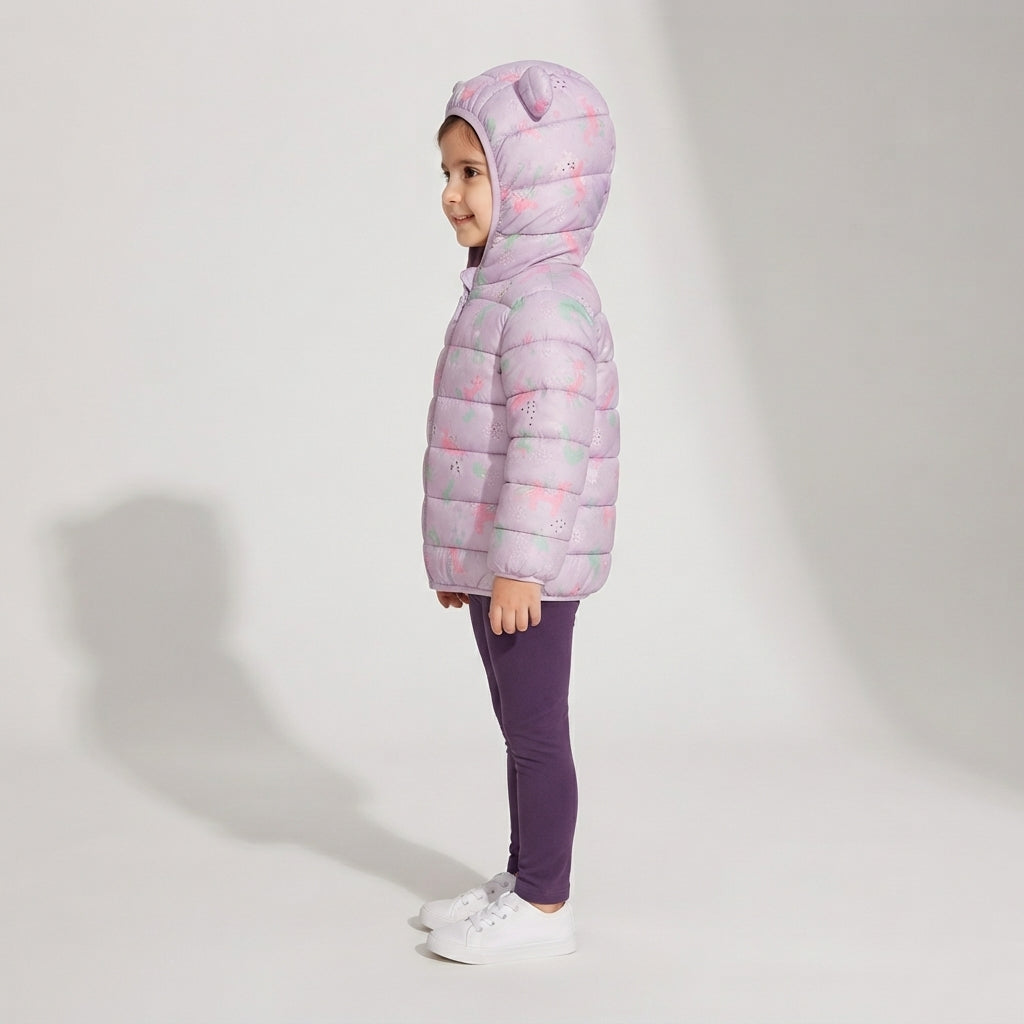 Niña vistiendo chaqueta acolchada EmpiBy con estampado de unicornios en tonos pastel y capucha con orejitas