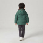Niño de espaldas vistiendo chaqueta acolchada verde EmpiBy con capucha forrada de borreguito estilo osito