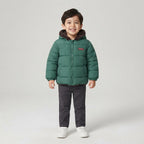 Niño sonriente vistiendo chaqueta acolchada verde EmpiBy con capucha forrada, ideal para el invierno.