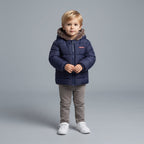 Niño pequeño vistiendo chaqueta azul marino EmpiBy con capucha de piel sintética y diseño acolchado cálido