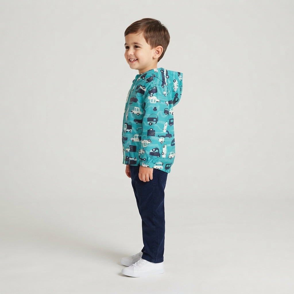Niño vistiendo chaqueta cortavientos EmpiBy azul con estampado de carros de carrera y capucha en fondo blanco.