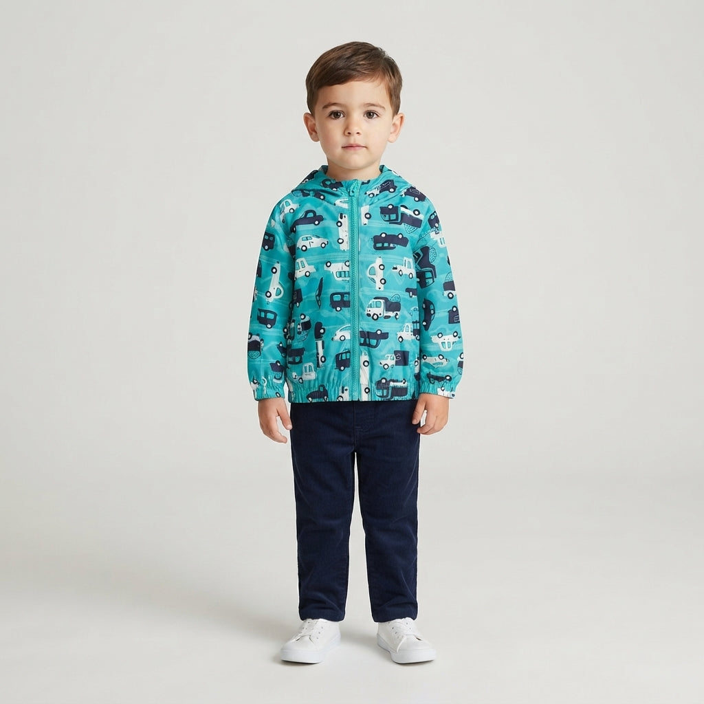 Niño vistiendo chaqueta cortavientos EmpiBy azul con estampado de carros de carrera y capucha sobre fondo neutro
