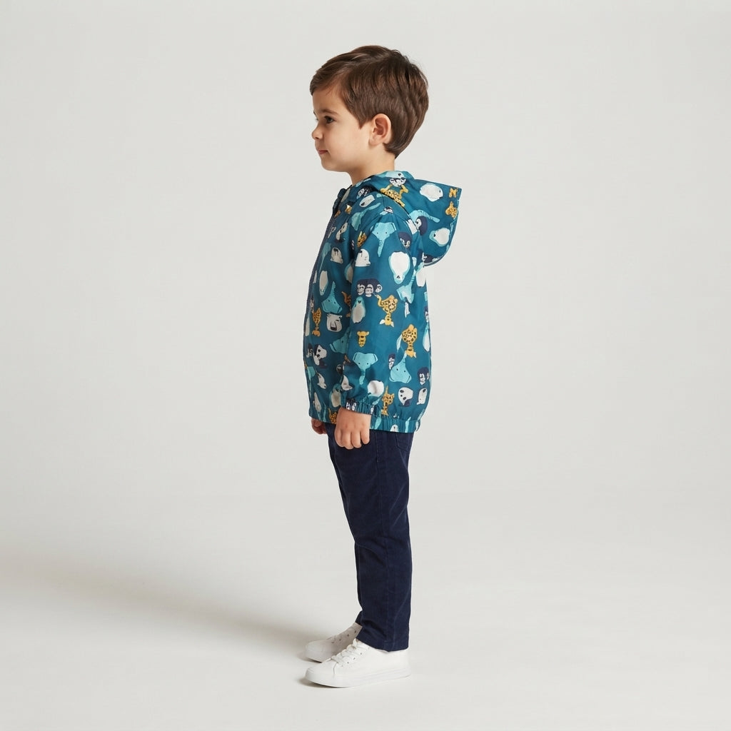 Niño de perfil vistiendo chaqueta cortavientos EmpiBy azul con estampado de animales de safari y capucha