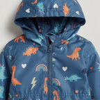 Chaqueta impermeable EmpiBy azul con estampado de dinosaurios, arcoíris y rayos, incluye capucha integrada.