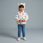 Niña vistiendo chaqueta acolchada EmpiBy con estampado marino y capucha con orejitas sobre fondo gris