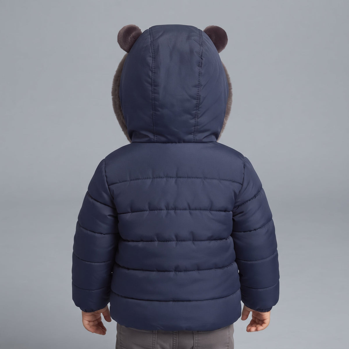 Chaqueta infantil EmpiBy azul marino con capucha de osito y detalles de piel sintética vista desde atrás