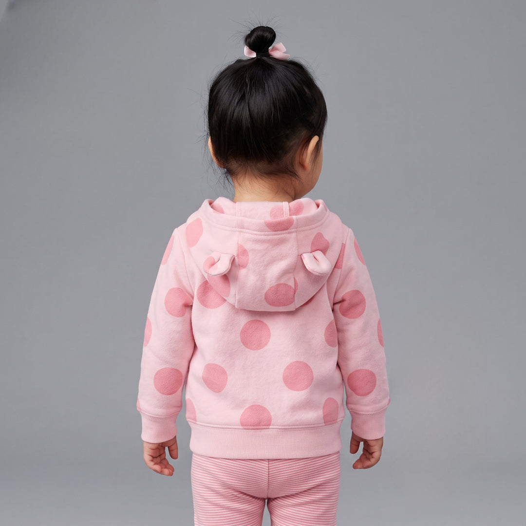 Vista trasera de niña con chaqueta EmpiBy rosa de lunares con capucha y orejitas 3D sobre pantalón de rayas