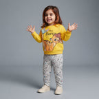 Niña pequeña vistiendo conjunto EmpiBy de sudadera amarilla con estampado de Bambi y pantalón jogger gris estampado.