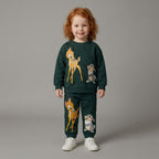 Niña sonriente vistiendo conjunto EmpiBy de dos piezas verde oscuro con estampado de Bambi y Tambor en algodón suave