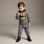 Niño vistiendo conjunto EmpiBy de dos piezas gris de Batman con sudadera de capucha y logo amarillo en el pecho