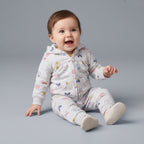 Bebé feliz vistiendo conjunto EmpiBy de tres piezas gris con estampado de animalitos, chaqueta con capucha y jogger