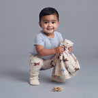 Bebé sonriente con conjunto EmpiBy de 3 piezas: body a rayas, pantalón y chaqueta con estampado de aviones.