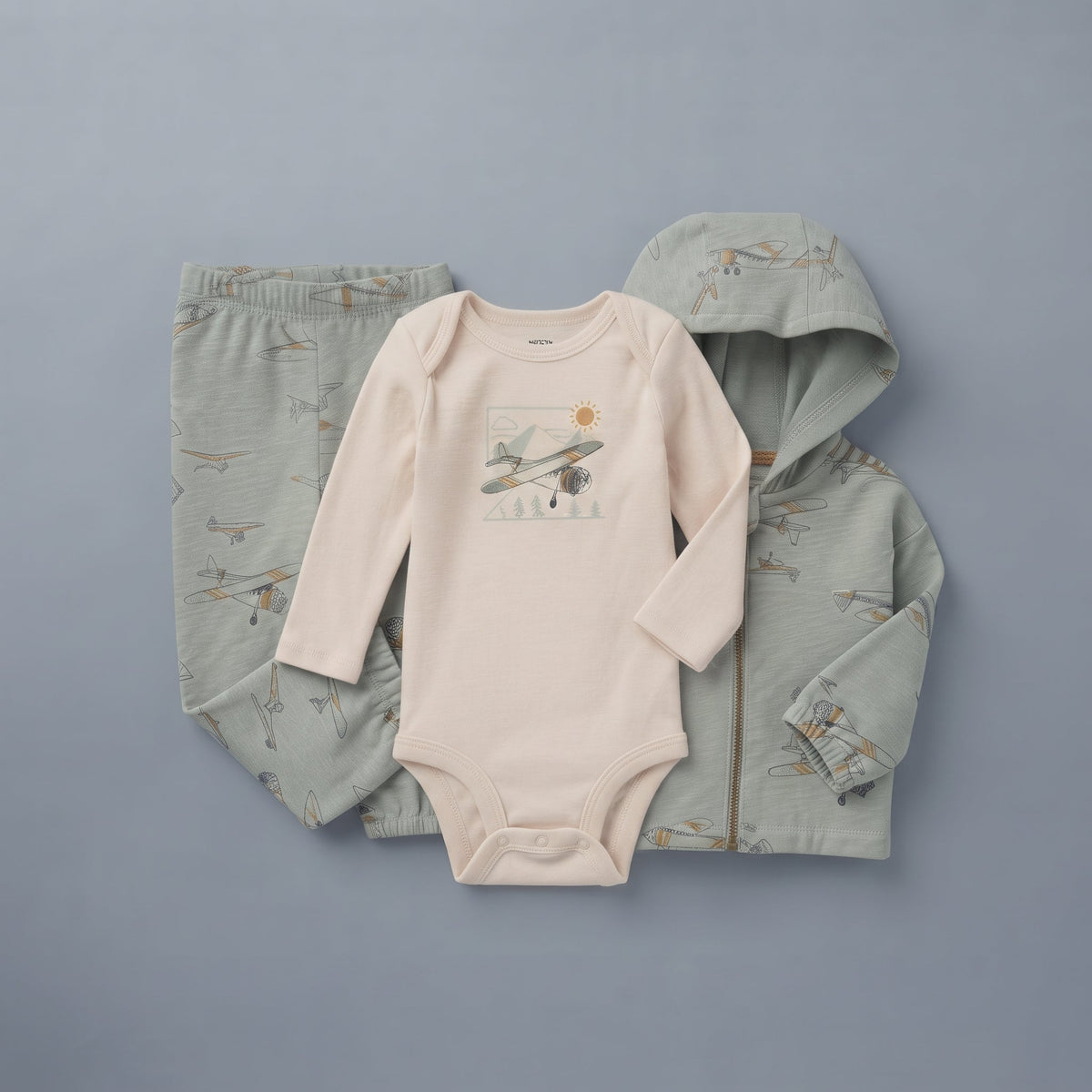 Conjunto de 3 piezas EmpiBy para bebé niño con chaqueta y pantalón verde salvia y body beige con estampado de aviones.