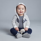 Bebé sonriente con conjunto EmpiBy de 3 piezas: chaqueta a rayas con ballena, body y pantalón azul marino.