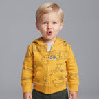Niño pequeño vistiendo conjunto EmpiBy de chaqueta amarilla con estampado de camiones, body gris y pantalón oscuro.