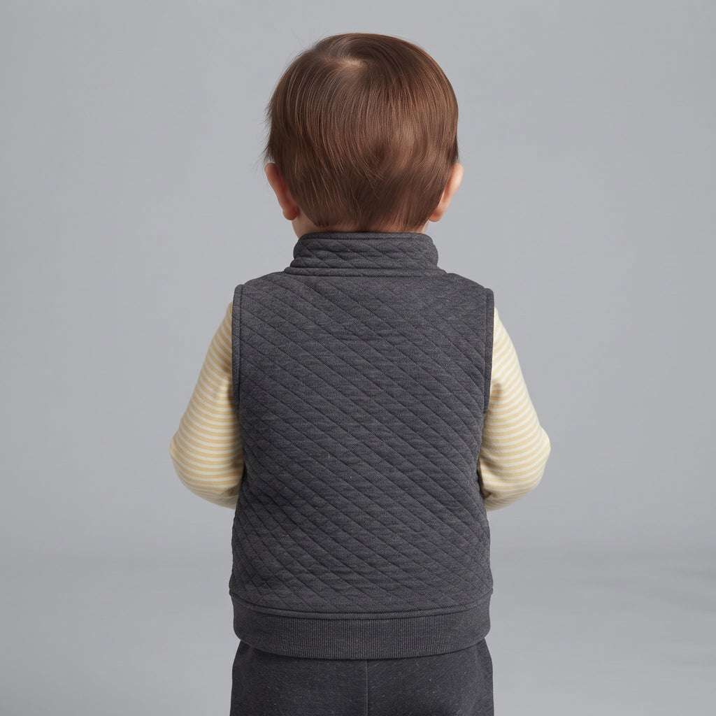 Vista trasera de bebé niño con conjunto EmpiBy de chaleco acolchado gris oscuro y body de rayas amarillas