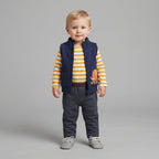Niño pequeño vistiendo conjunto EmpiBy de 3 piezas: chaleco azul marino con mamut, body a rayas y pantalón gris.