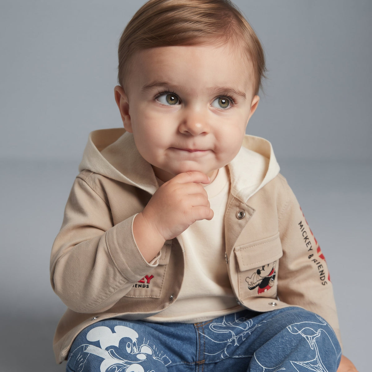 Bebé con conjunto EmpiBy de chaqueta caqui con capucha y pantalón de mezclilla azul con estampado de Mickey Mouse