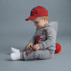 Bebé con conjunto EmpiBy de sudadera gris con capucha y jogger Chicago Bulls, incluye gorra roja y zapatillas blancas