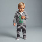 Bebé con conjunto EmpiBy de 3 piezas: chaqueta gris con cocodrilo, body estampado y pantalón a rayas grises y blancas.