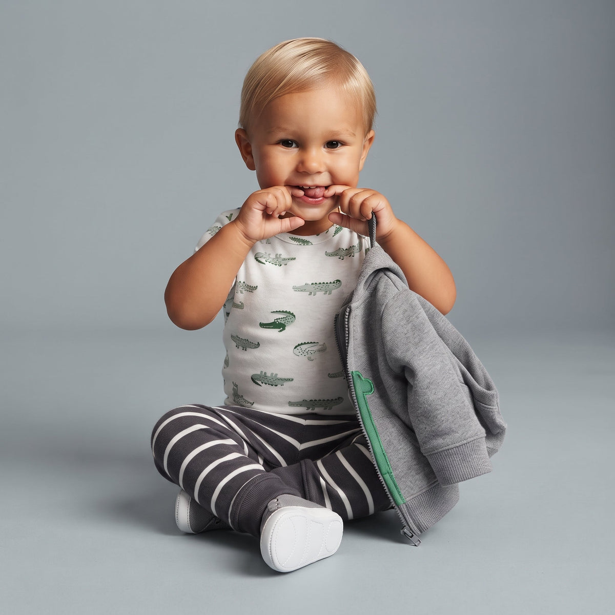 Bebé niño EmpiBy con conjunto de 3 piezas: body de cocodrilos, pantalón a rayas y chaqueta gris con cremallera.