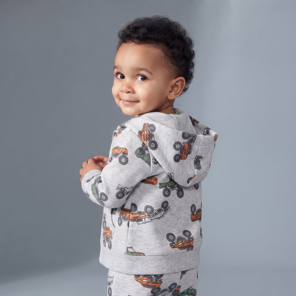 Bebé niño vistiendo chaqueta con capucha gris EmpiBy con estampado de cuatrimotos naranjas y verdes