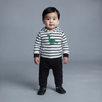 Bebé con conjunto EmpiBy de 3 piezas: buzo a rayas con dinosaurio, pantalón negro y body, estilo casual y cómodo.