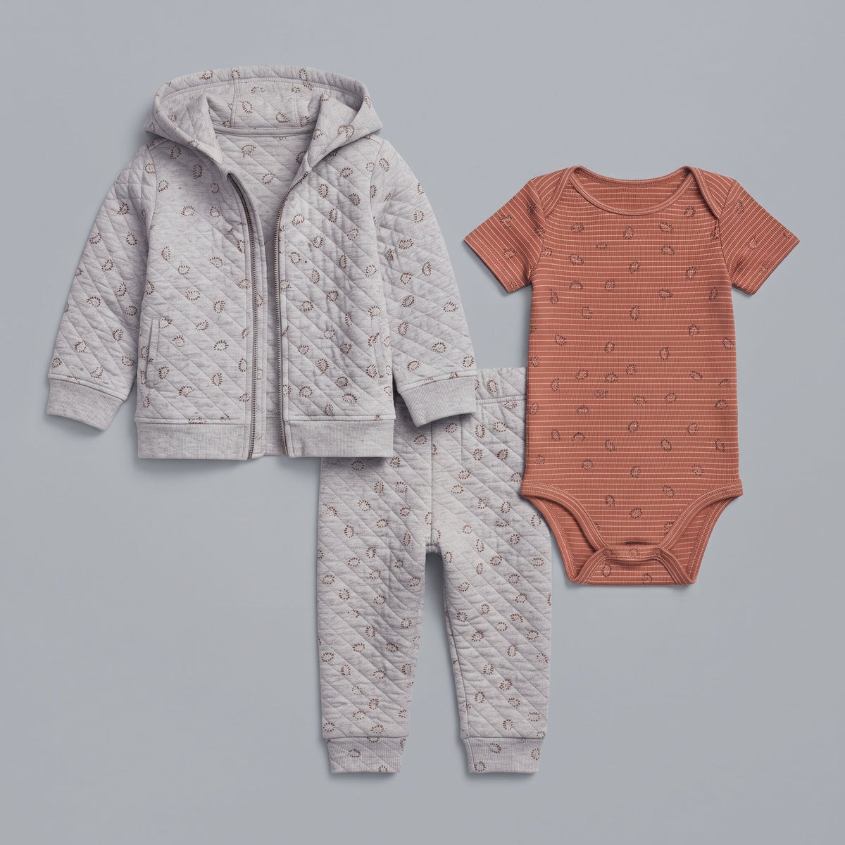 Conjunto EmpiBy de 3 piezas para bebé niño con chaqueta acolchada gris, pantalón a juego y body terracota a rayas.