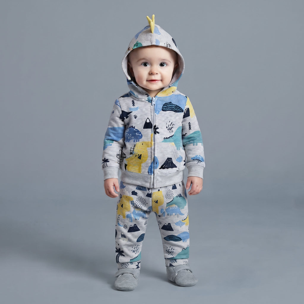 Bebé con conjunto EmpiBy de tres piezas gris con estampado de dinosaurios, chaqueta con capucha y pantalón a juego.