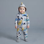 Bebé con conjunto EmpiBy de tres piezas gris con estampado de dinosaurios, chaqueta con capucha y pantalón a juego.