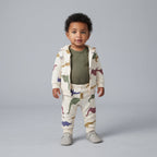 Bebé con conjunto EmpiBy de 3 piezas: chaqueta y pantalón beige con dinosaurios y body verde oliva de manga larga.