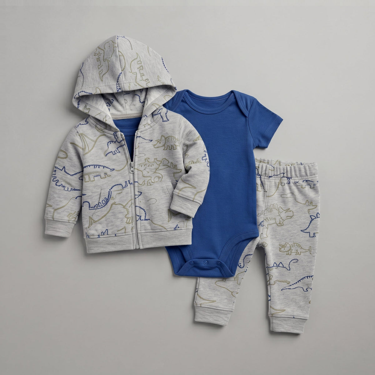 Conjunto EmpiBy de 3 piezas para bebé niño con chaqueta gris de dinosaurios, body azul y pantalón a juego.