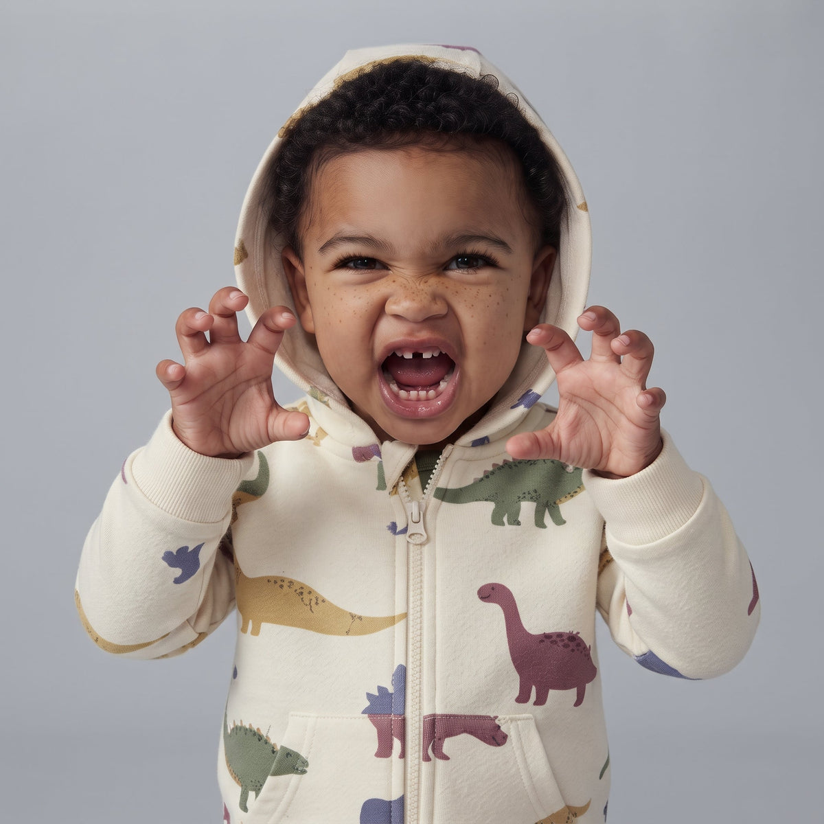 Bebé niño con conjunto EmpiBy de tres piezas con estampado de dinosaurios, chaqueta con capucha y crestas divertidas.