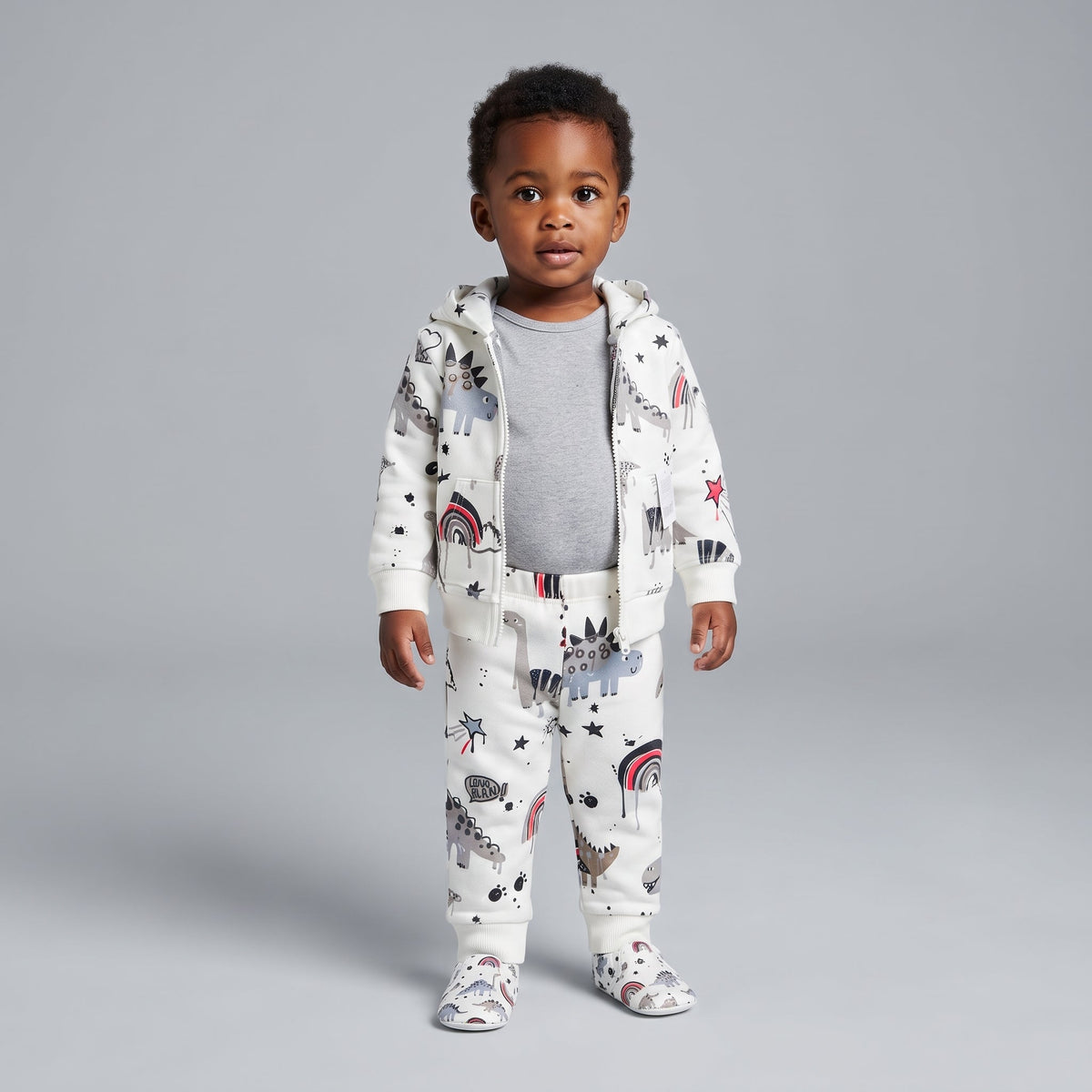 Bebé con conjunto EmpiBy de 3 piezas: chaqueta y pantalón con estampado de dinosaurios y body gris de manga larga.